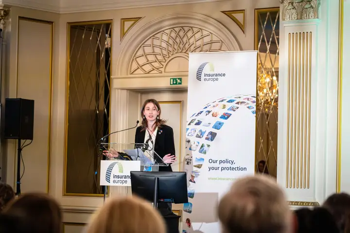 A speaker at the lectern, seen over the audience