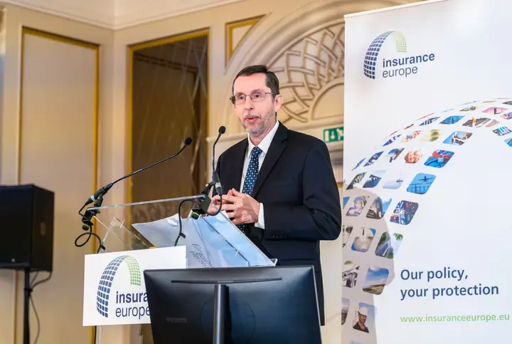 A speaker at the lectern beside the Insurance Europe banner