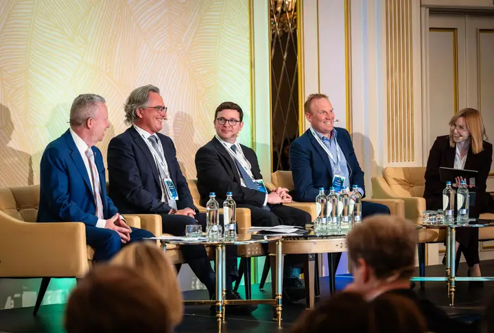 A panel of five speakers on stage