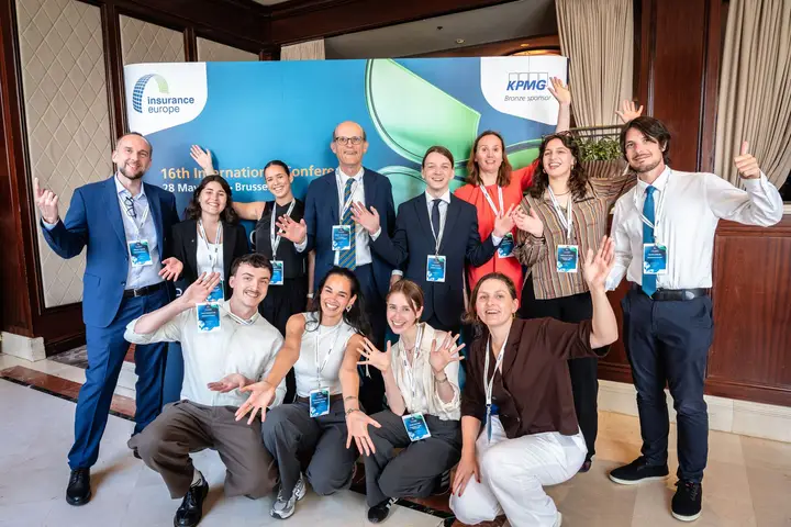 Young professionals posing at the conference photo wall